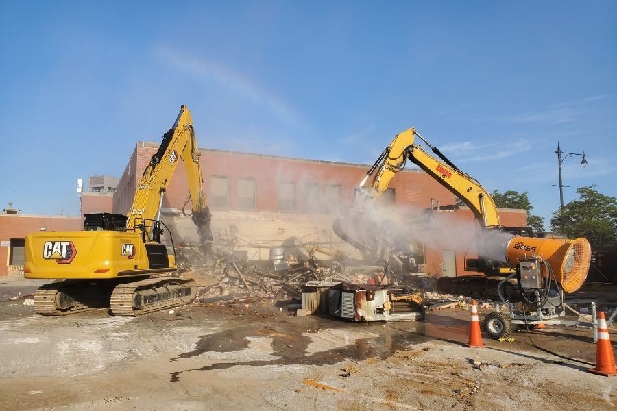 Alpine Demolition excavators at a construction site, a mist machine being used for demolition dust control 