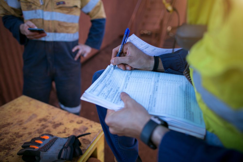 a construction worker is sitting at a table reading over a permit.