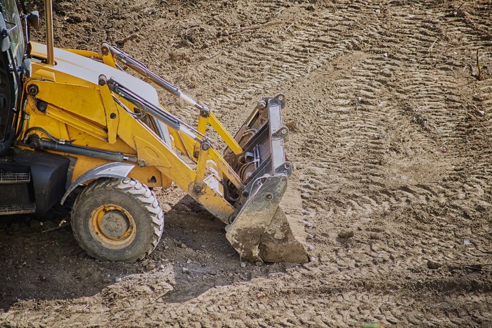 A yellow bulldozer is moving dirt on a construction site.