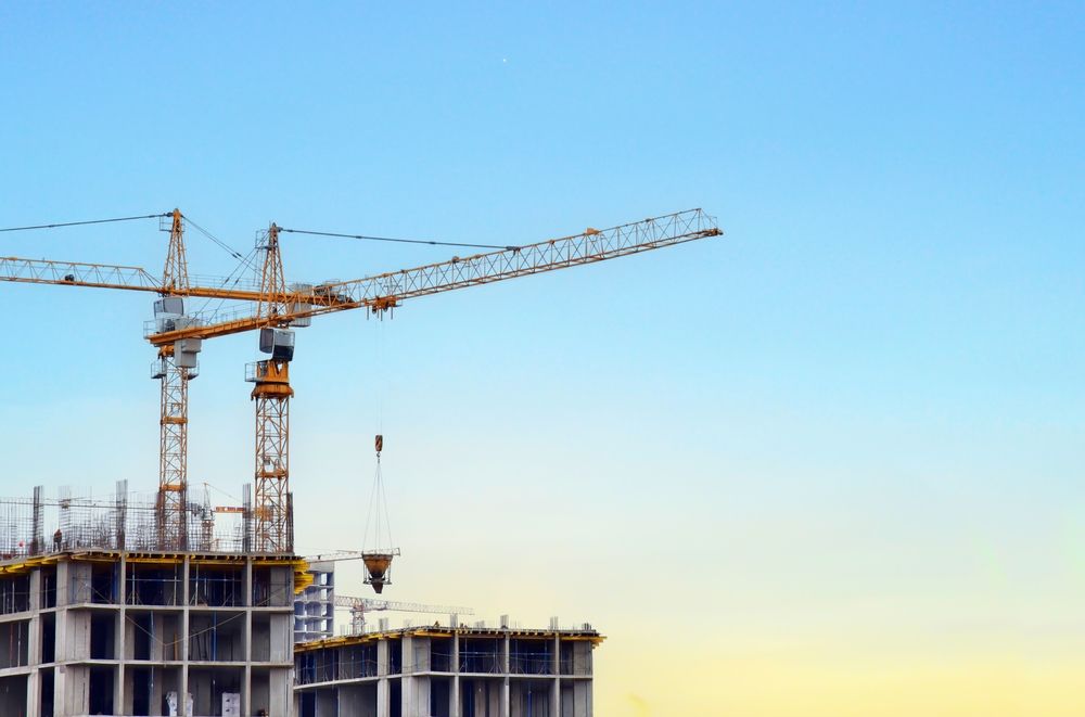 A construction site with cranes and a building under construction.