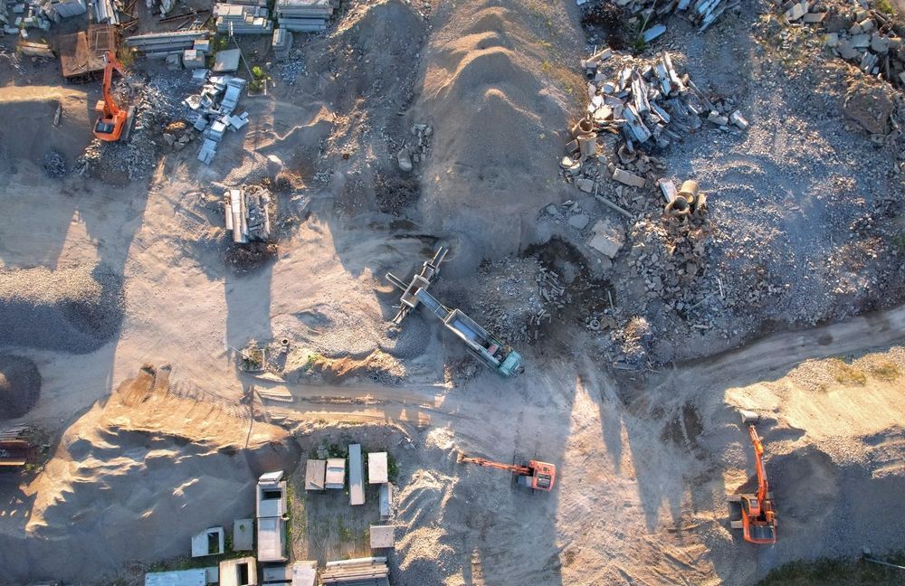 Aggregate recycling of concrete and asphalt with excavator loading construction waste at crushing site