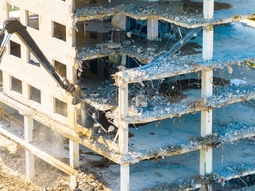 Above-grade structure demolition of a multi story commercial building using a high reach excavator
