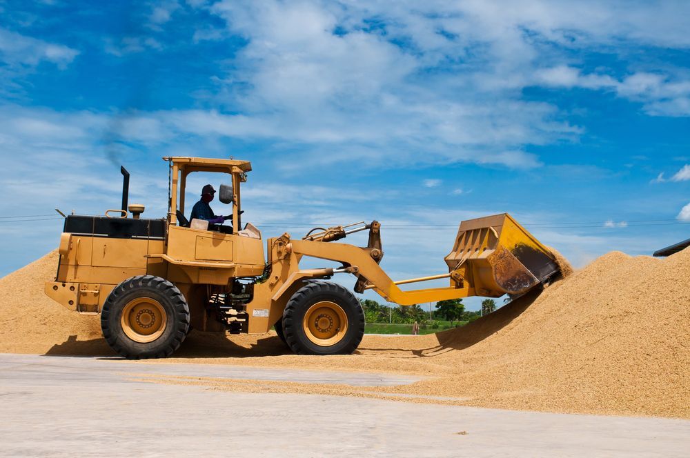 A bulldozer is loading a pile of gravel into a bucket.