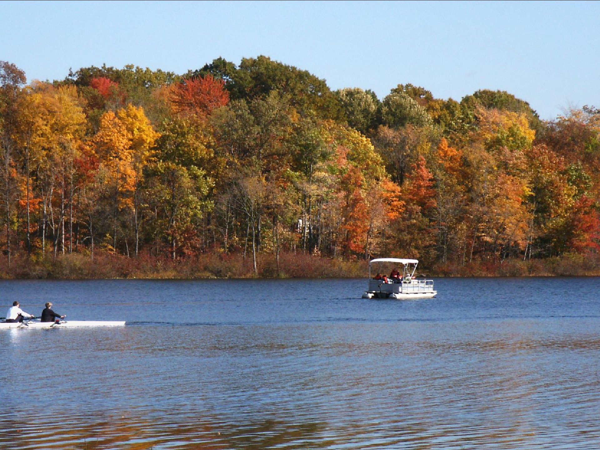 a boat is floating on a lake with trees in the background