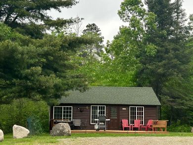 a small house with a green roof and a bench on the porch .