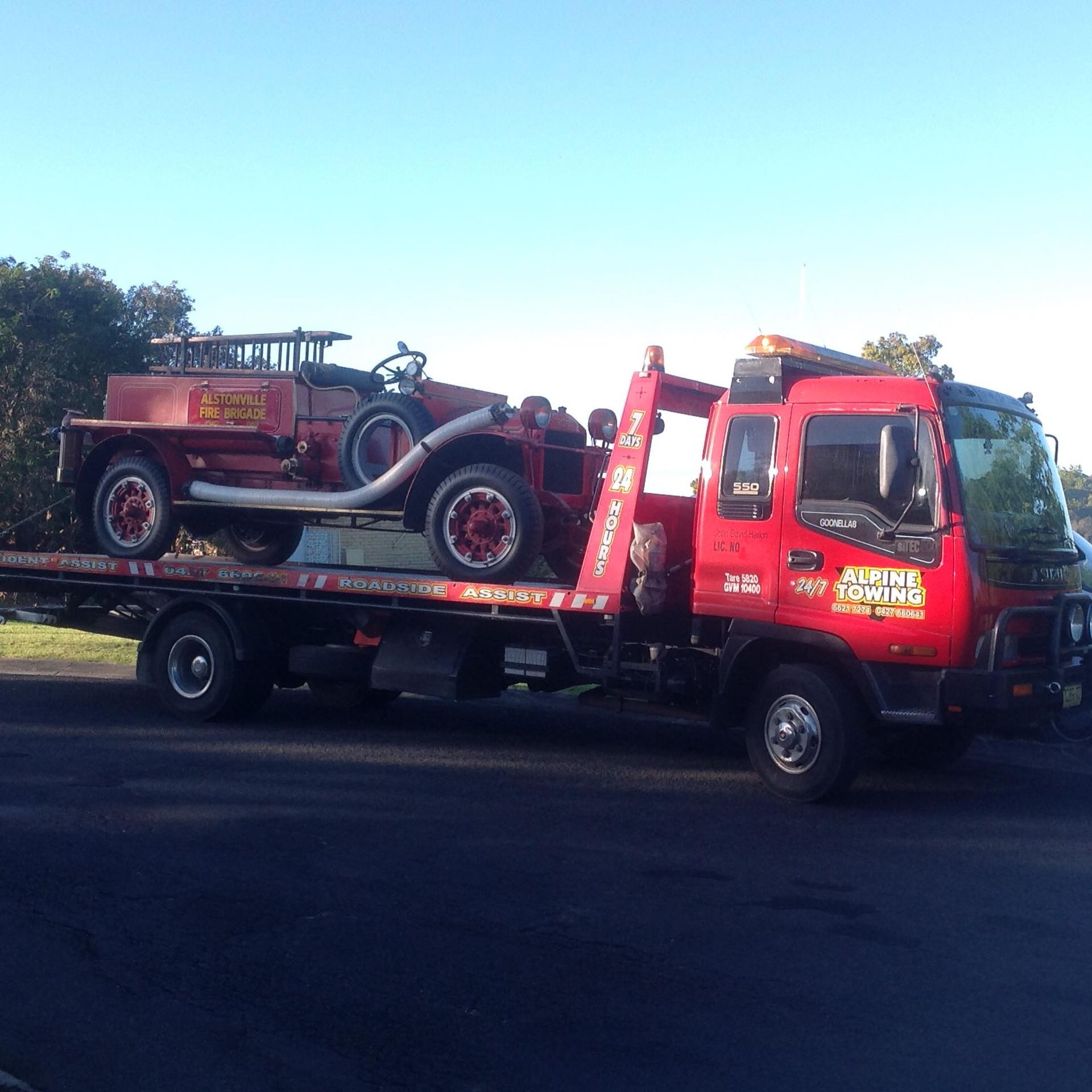 A Classic Fire Brigade Truck On Back Of Tow Truck — Alpine Towing Services in Ballina, NSW