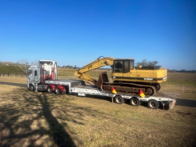 Excavator On Back Of a Tow Truck — Alpine Towing Services in Lismore, NSW
