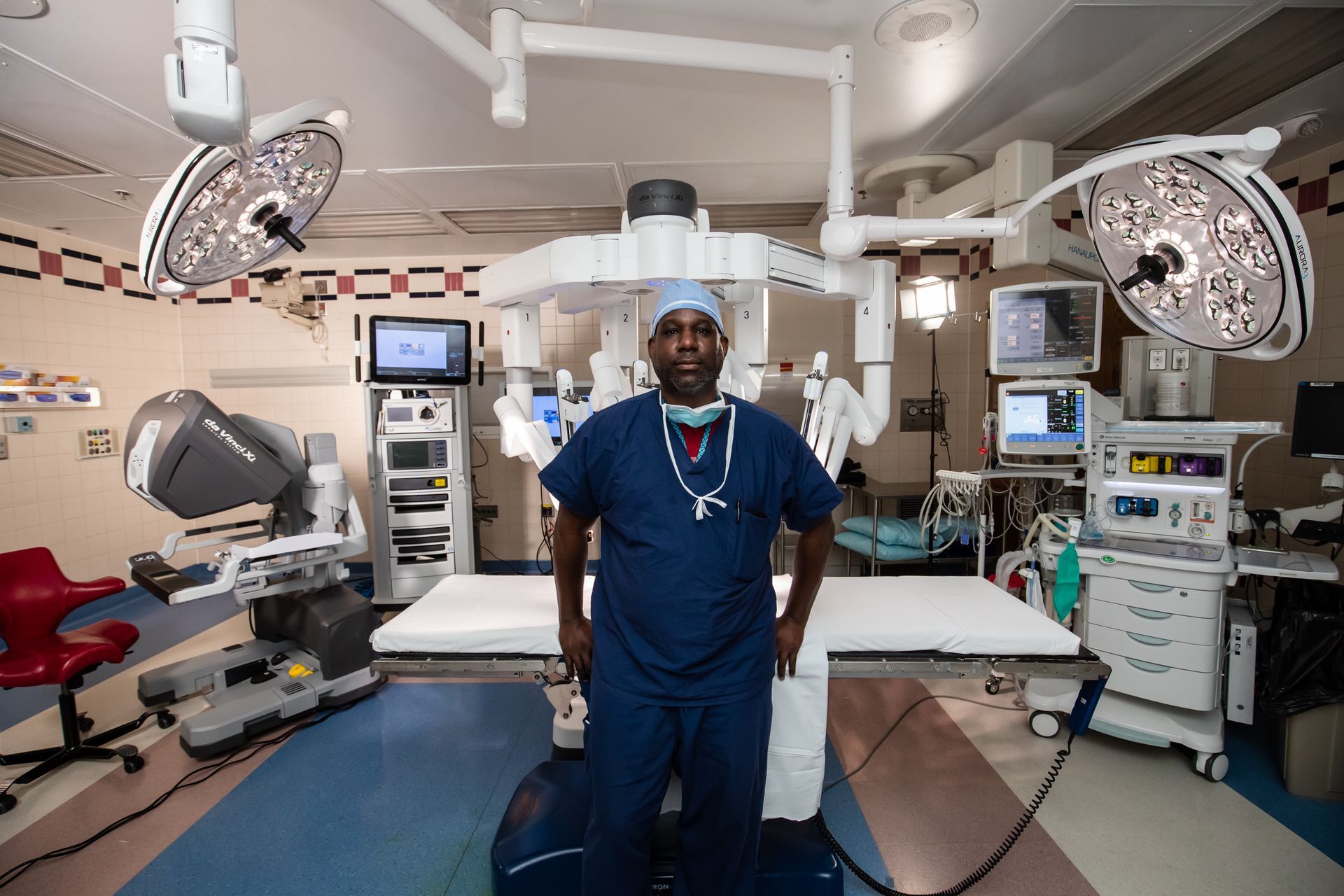 Surgeon standing in a modern operating room with surgical lights and equipment around him