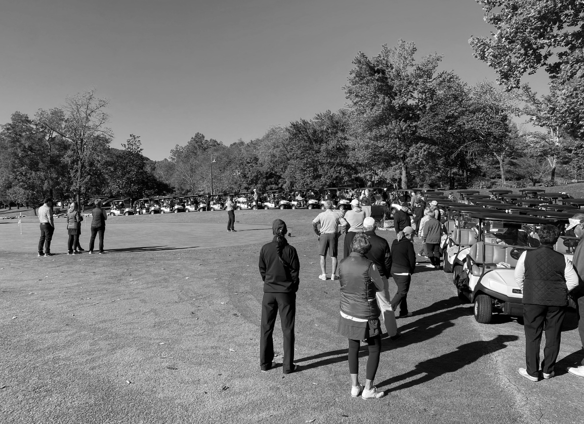 A black and white photo of a group of people standing in a field.