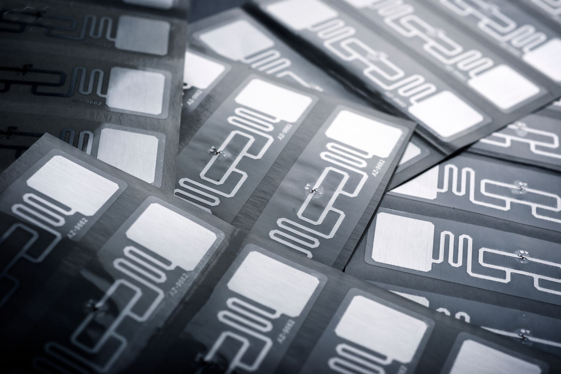 RFID tags in a pile; rectangular with integrated circuits and white squares.
