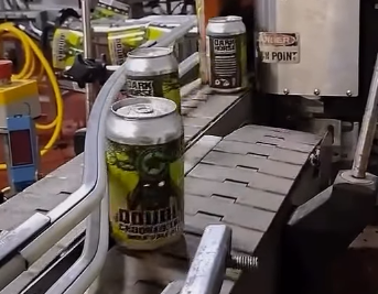 Cans of beer on a conveyor belt in a brewery.