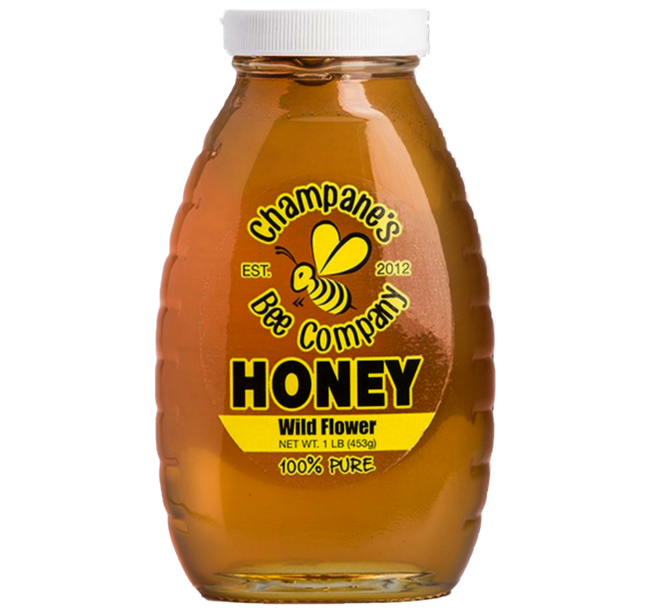 Jar of Champagne's Bee Company wild flower honey; yellow label with bee logo, white cap.