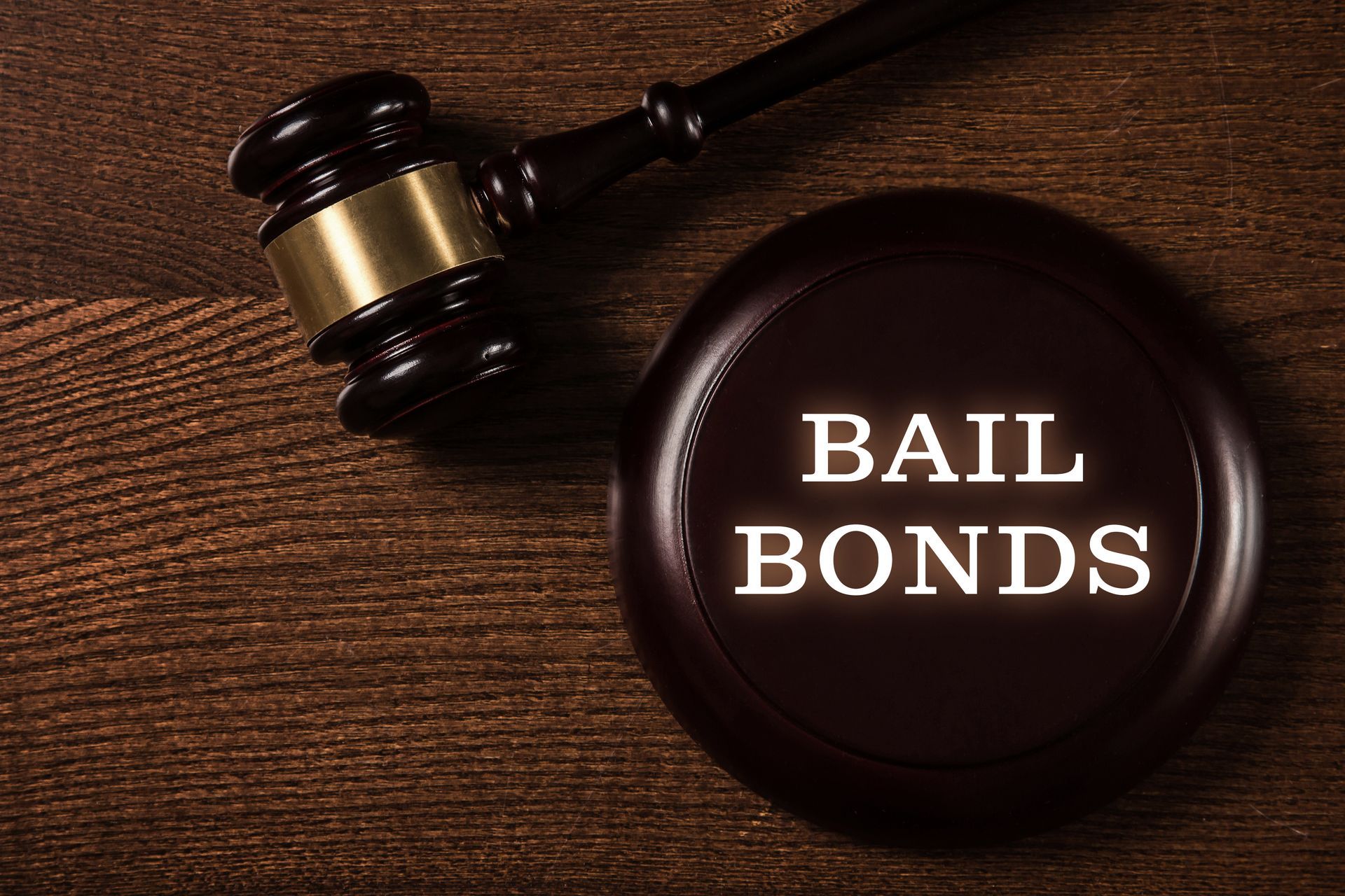 Gavel and round seal reading Bail Bonds on wooden surface.