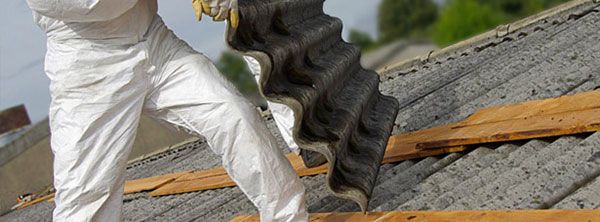 A man in white pants is working on a roof.