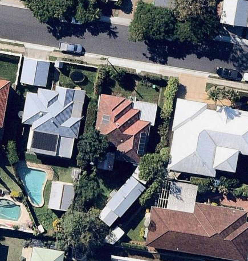 An aerial view of a residential area with houses and a pool