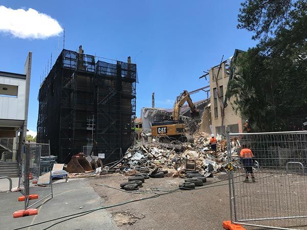 A large building is being demolished by a bulldozer.