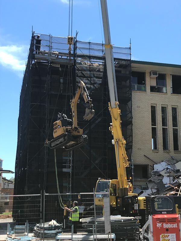 A construction site with a large building and a crane.