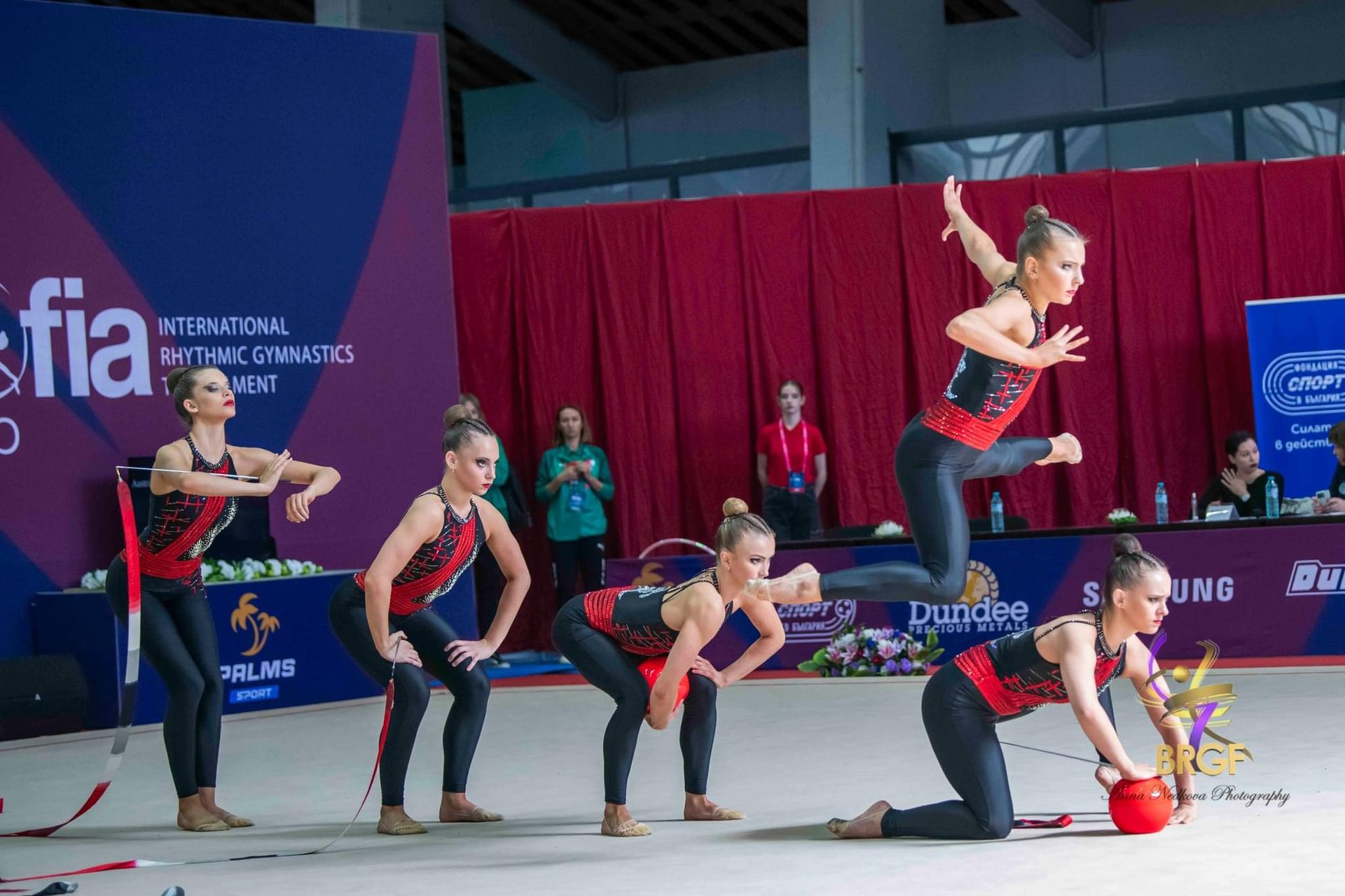 A group of female gymnasts are performing on a stage.