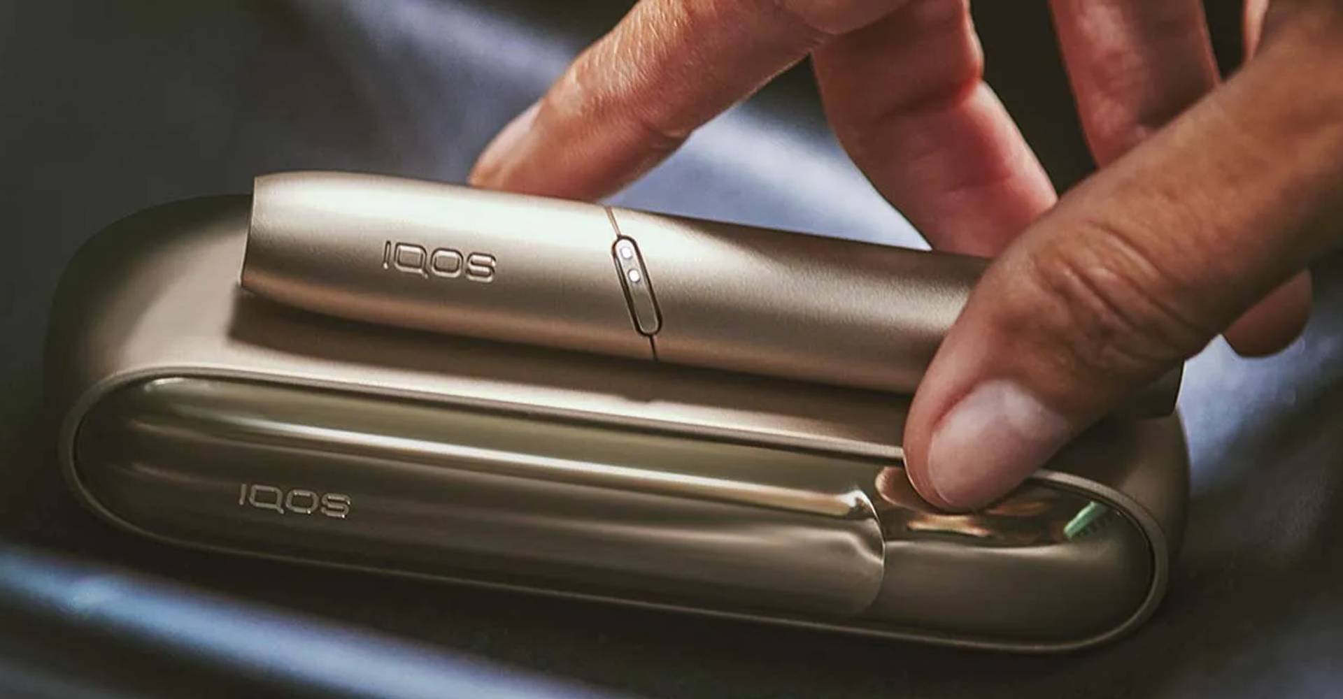 Mano della persona che inserisce il dispositivo elettronico nella custodia dorata del caricabatterie.