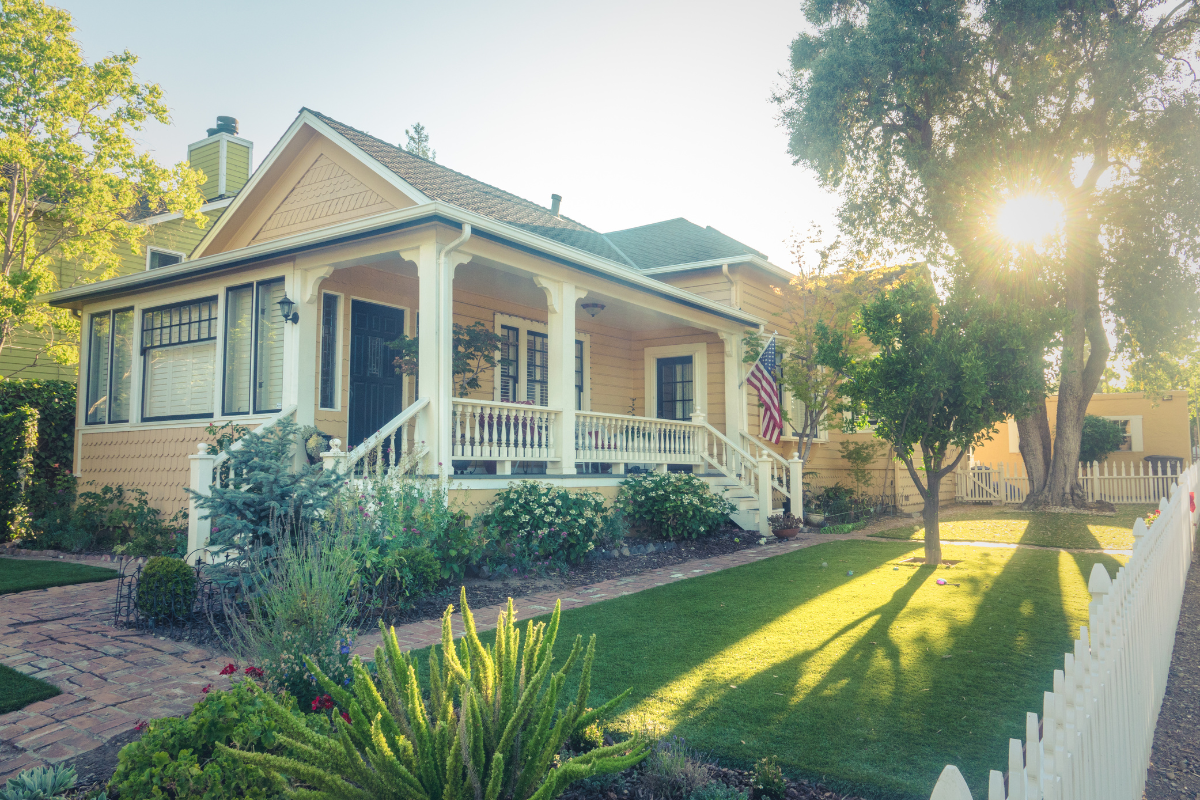 A house with a porch and a white picket fence