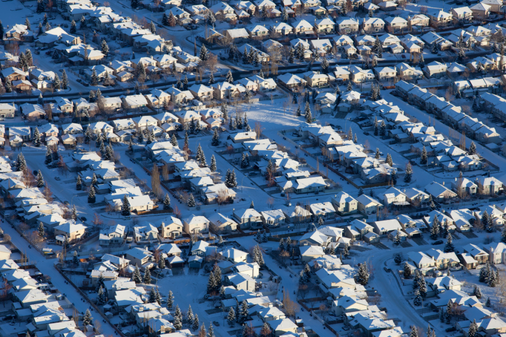 An aerial view of a residential area covered in snow