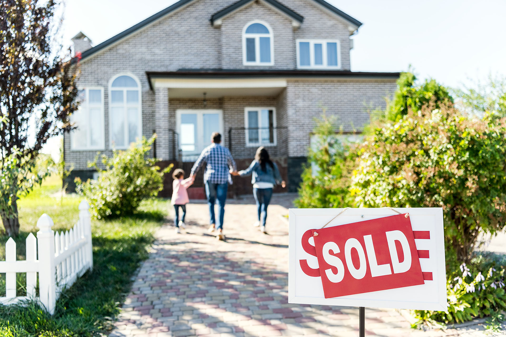 Family walking toward their new home with a sold sign in North Carolina