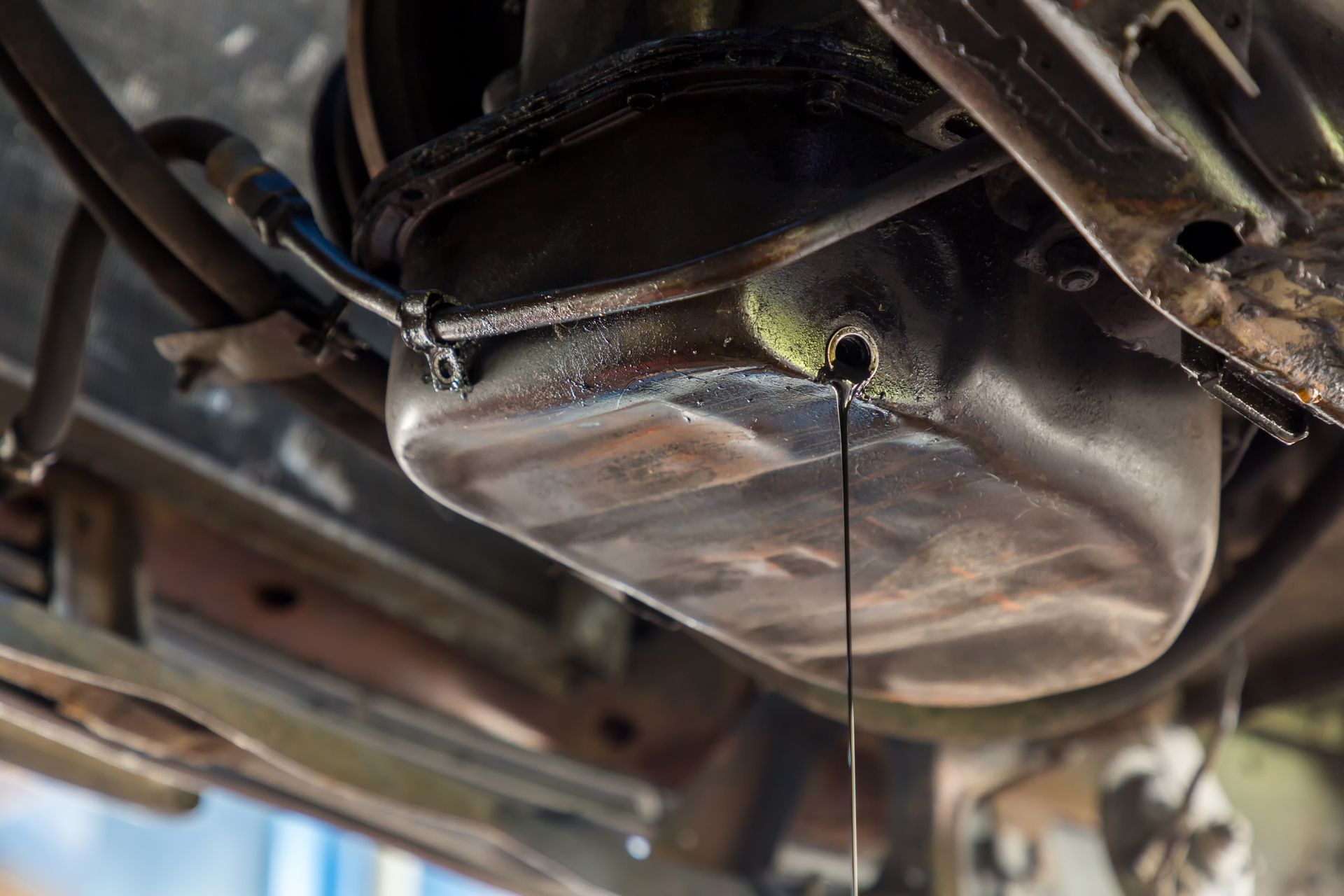 A close up of a car oil pan with oil leaking out of it | Beachview Auto Service