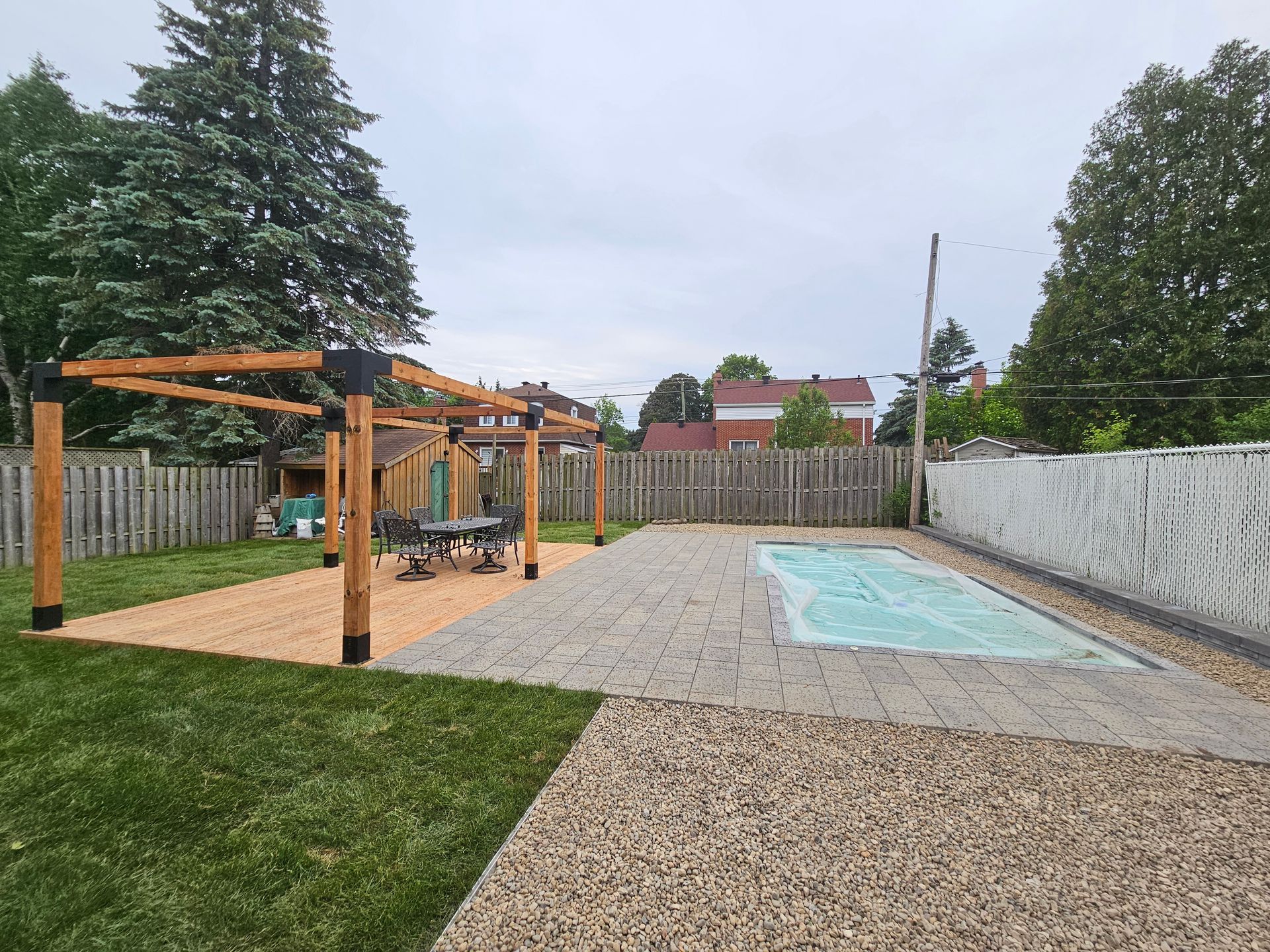 Une cour arrière avec une piscine et une pergola.
