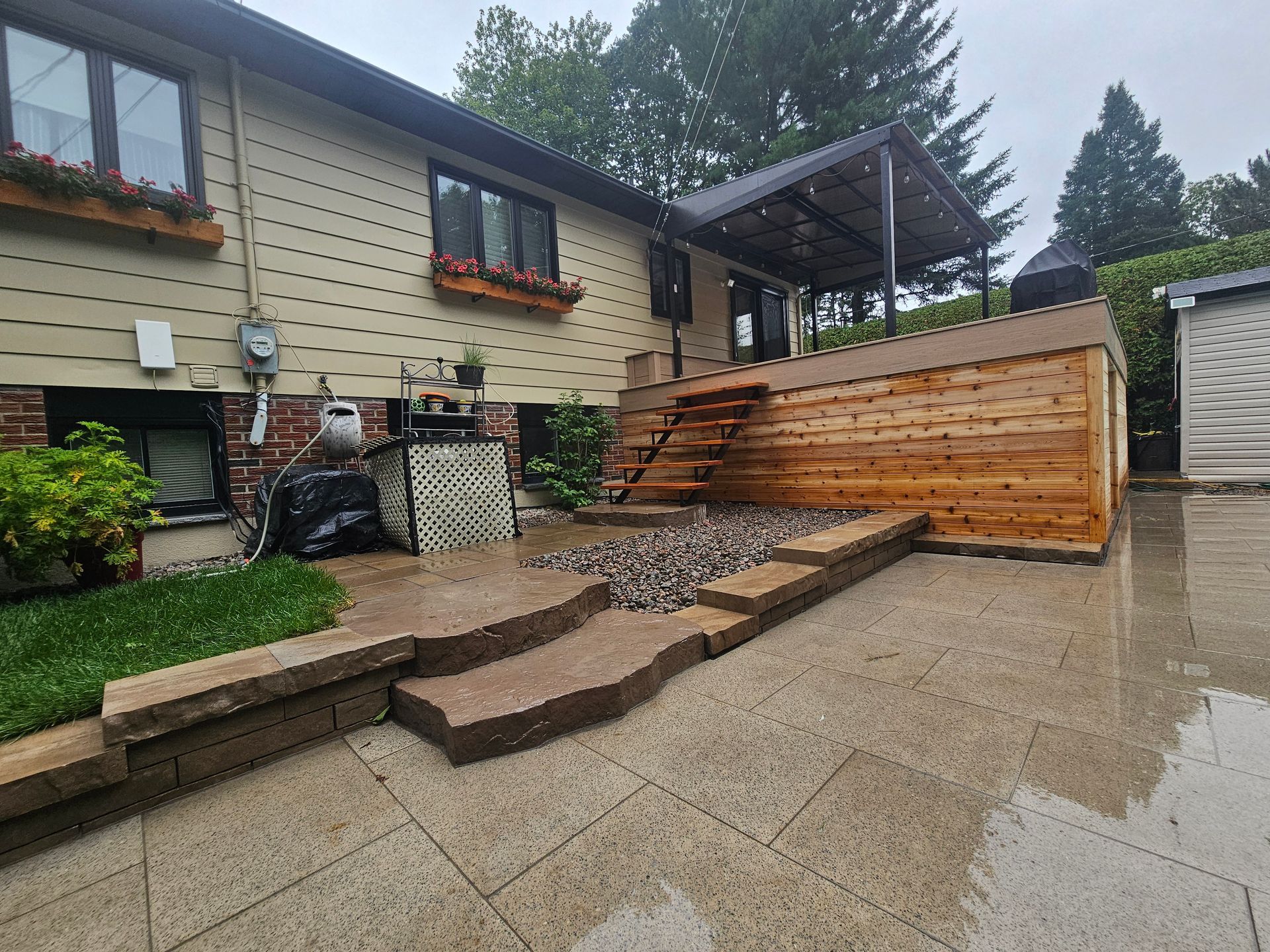 Une maison avec une terrasse en bois et des escaliers devant.