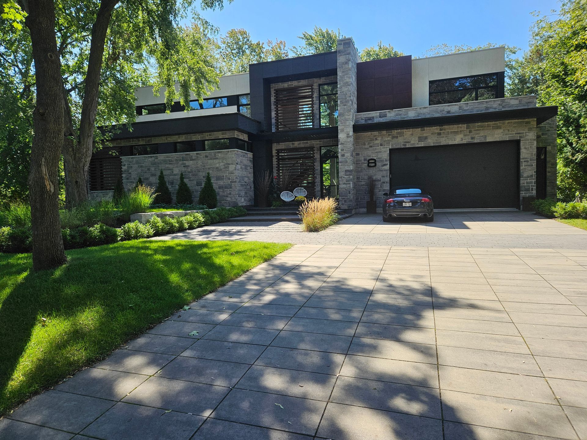 Une grande maison avec une voiture garée devant.