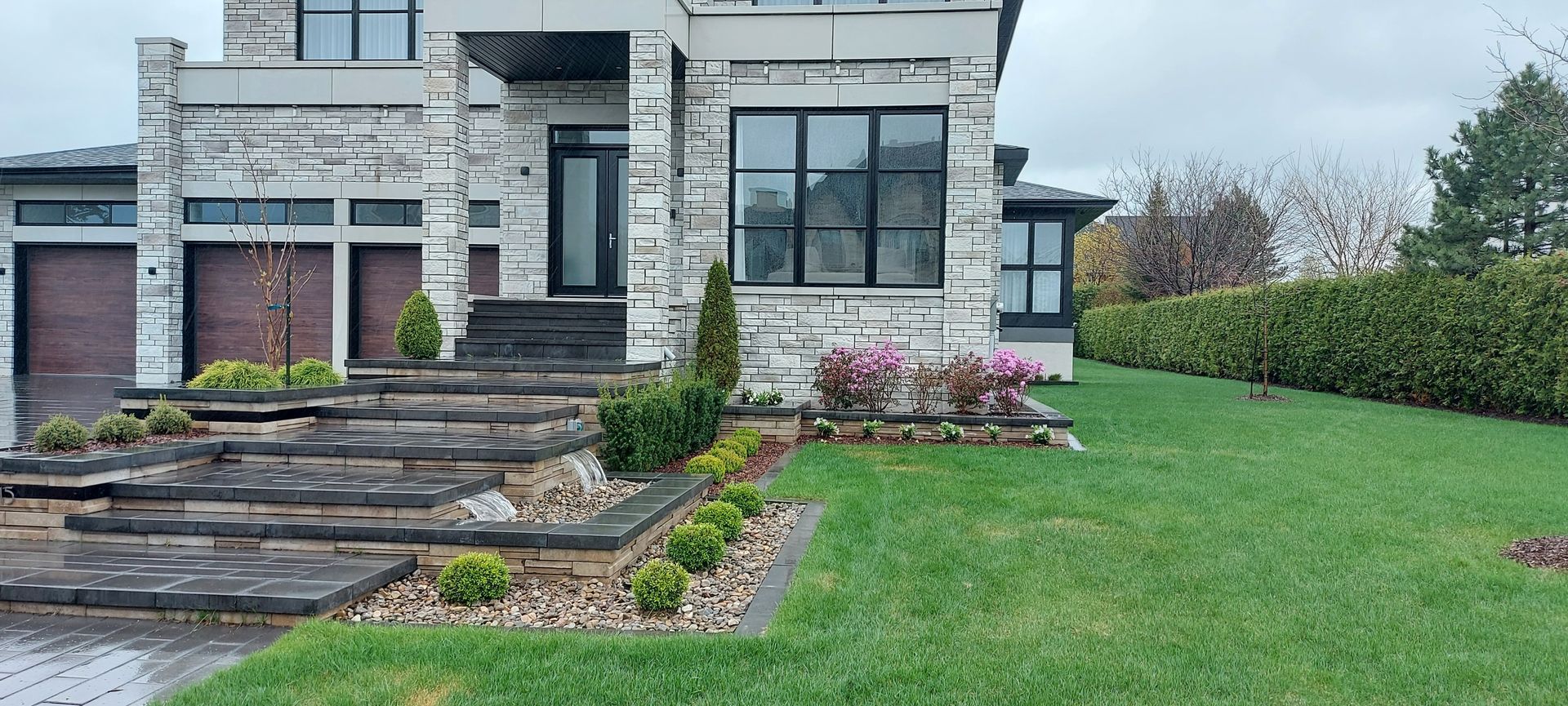 Une grande maison en briques avec une pelouse verte luxuriante devant elle.