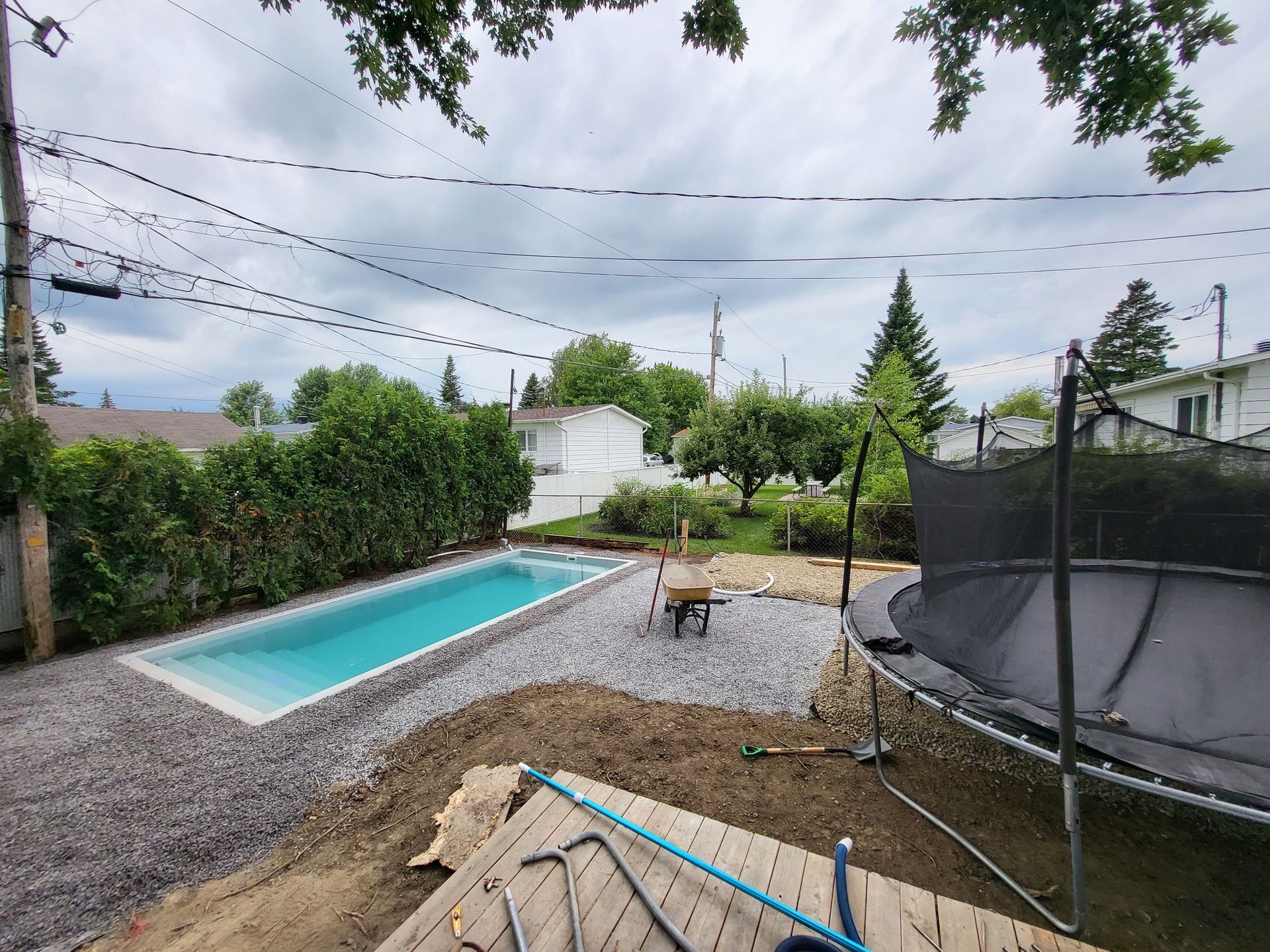 Une grande piscine est en cours de construction dans l'arrière-cour d'une maison.