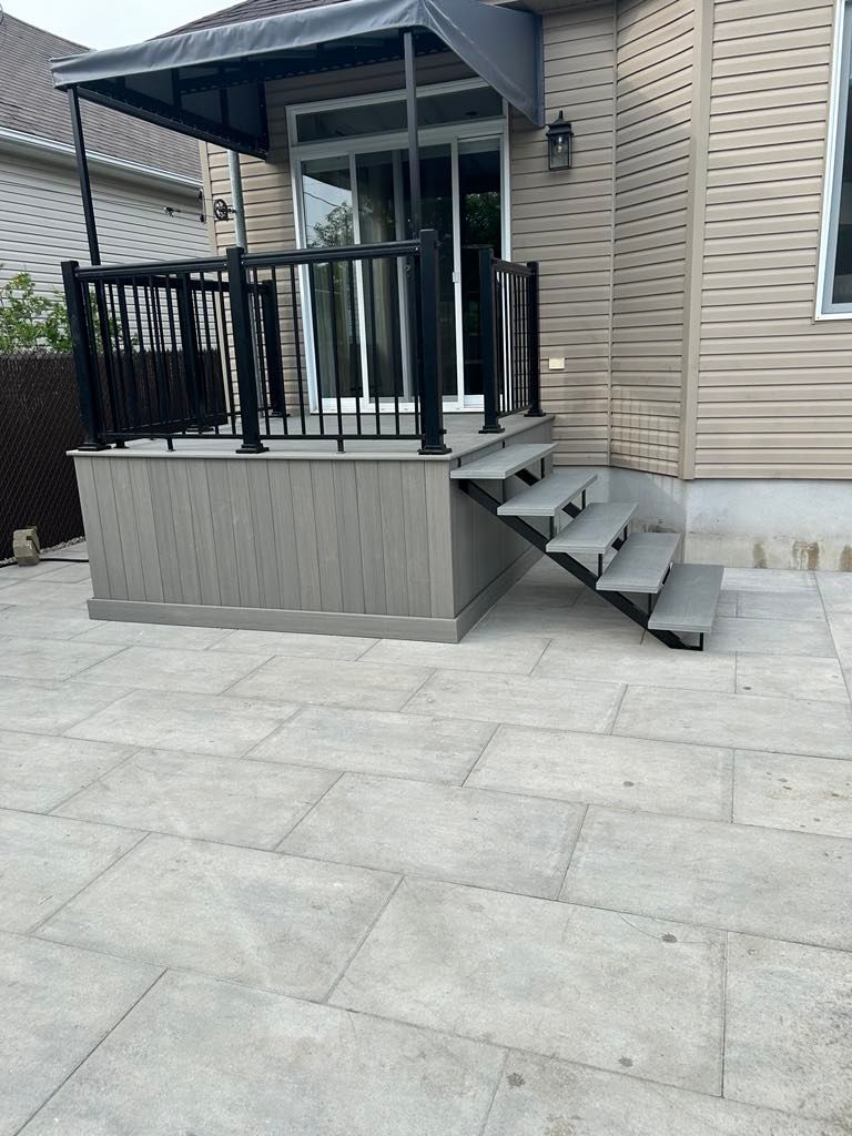 Une terrasse avec des escaliers qui y mènent et un auvent au-dessus