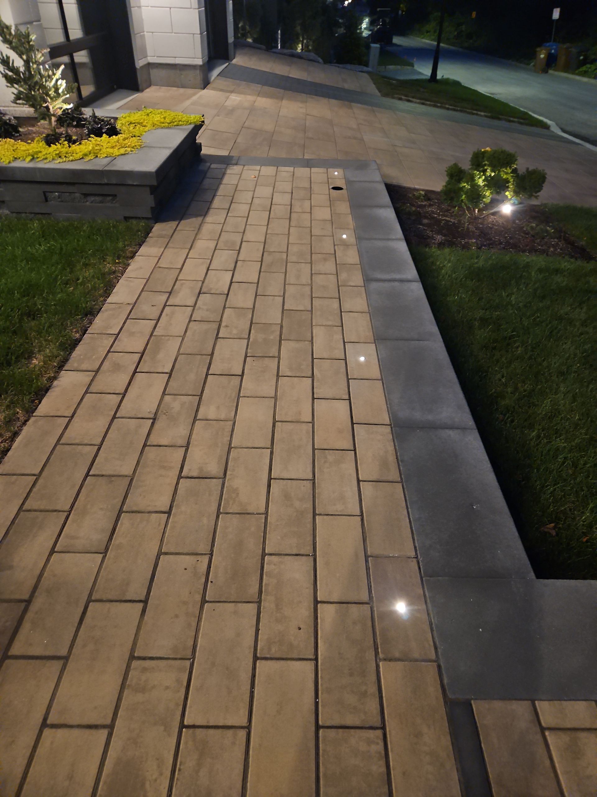 Une allée en briques menant à une maison la nuit