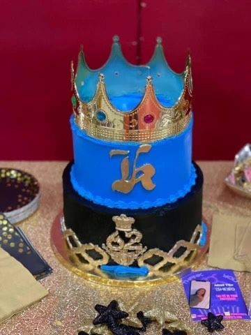 A blue and black cake with a crown on top