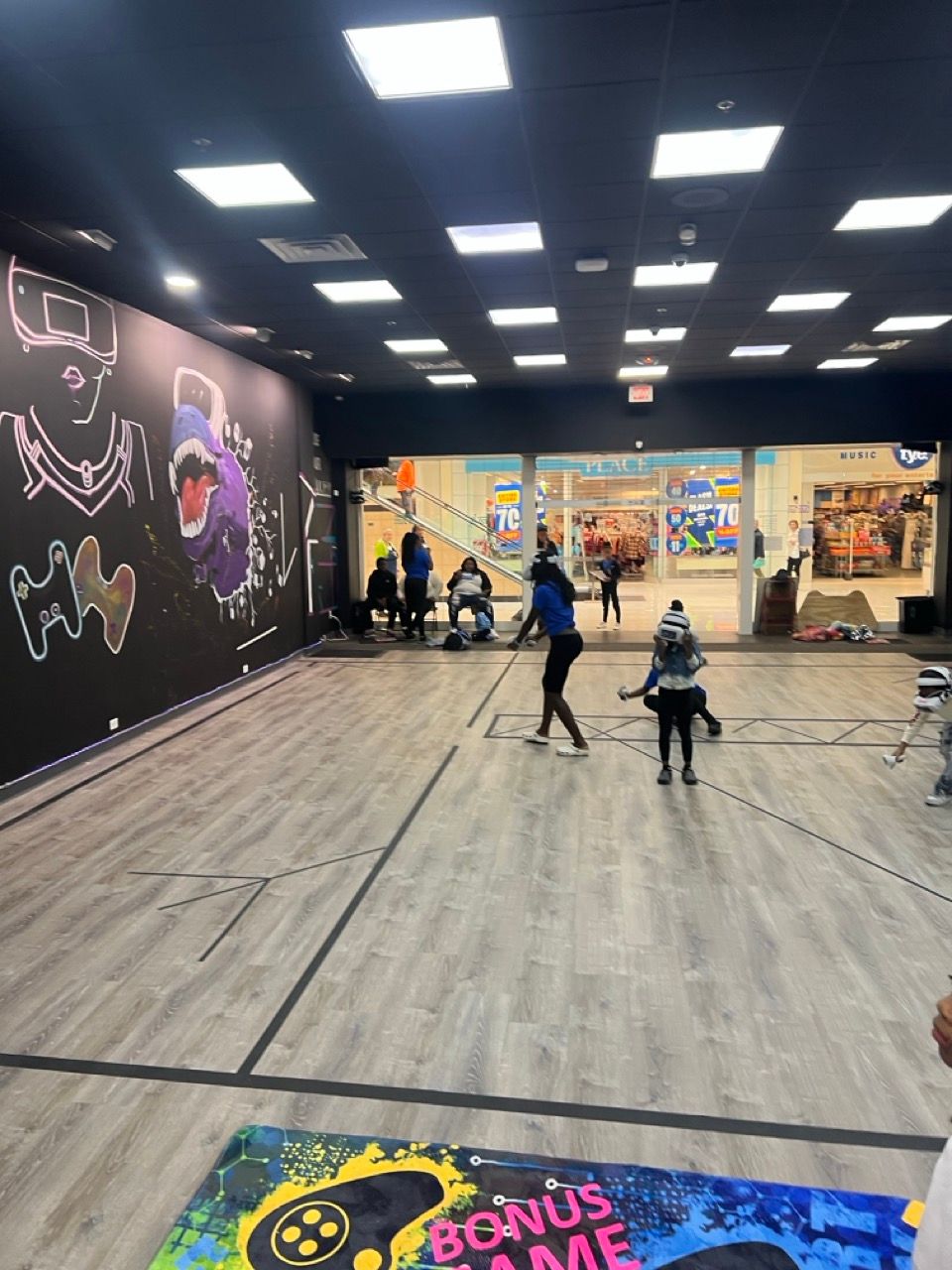 People are playing a game in a room with a sign that says bonus game