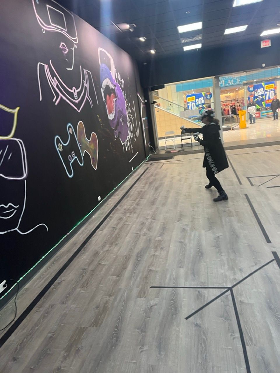 A person is standing in front of a wall with drawings on it