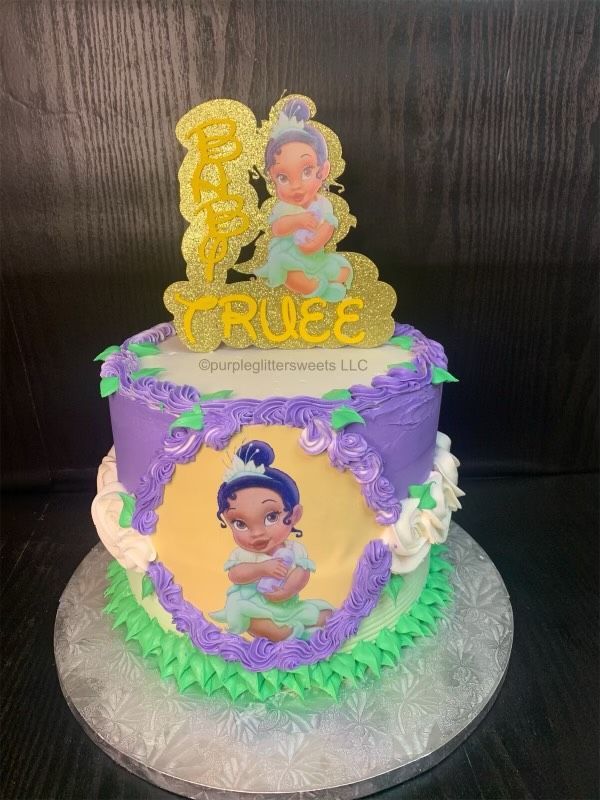 A purple cake with a picture of a baby on it