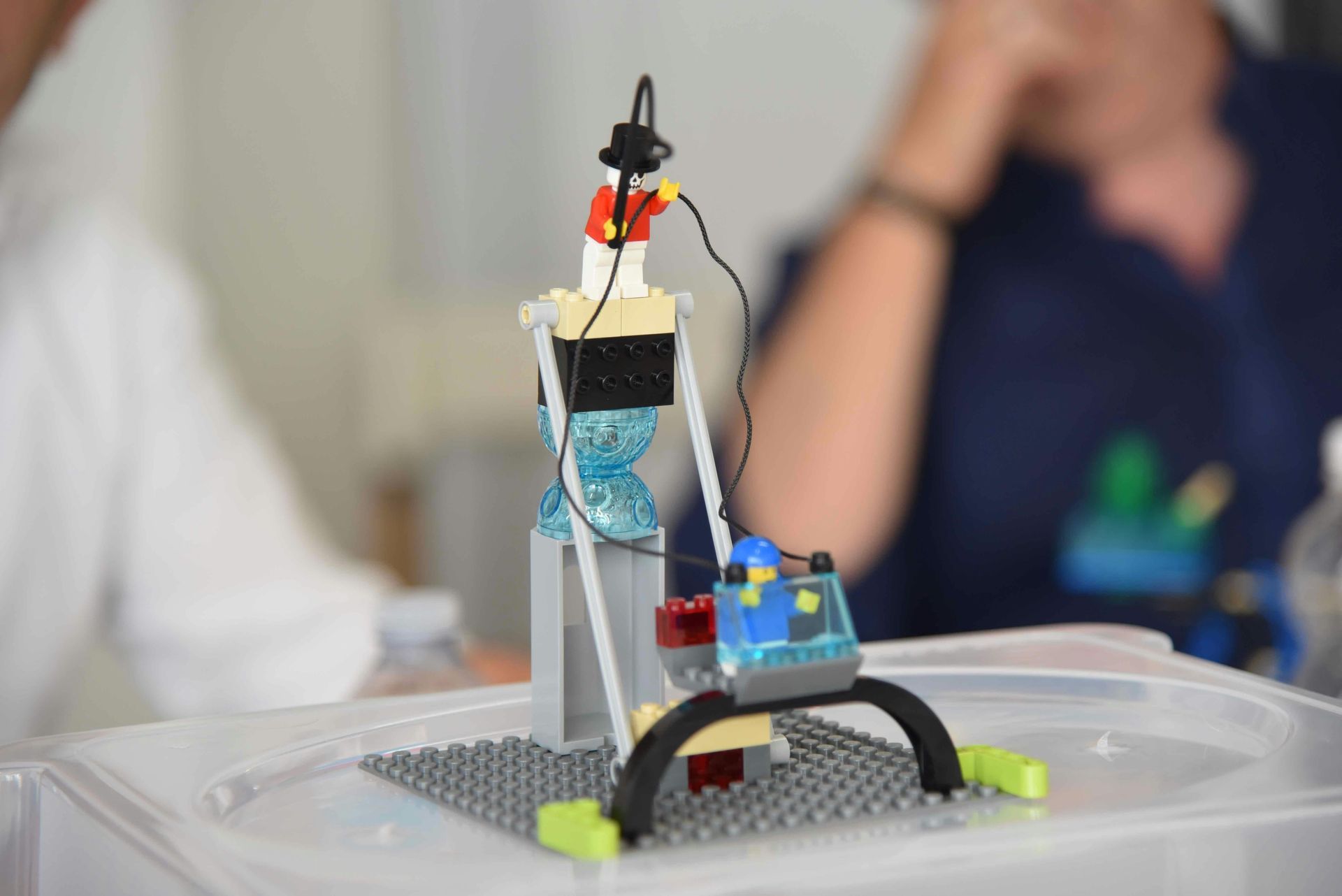 Lego structure with wires and a small motor, likely a science experiment, on a gray base.