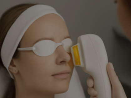 A woman is getting a laser treatment on her face