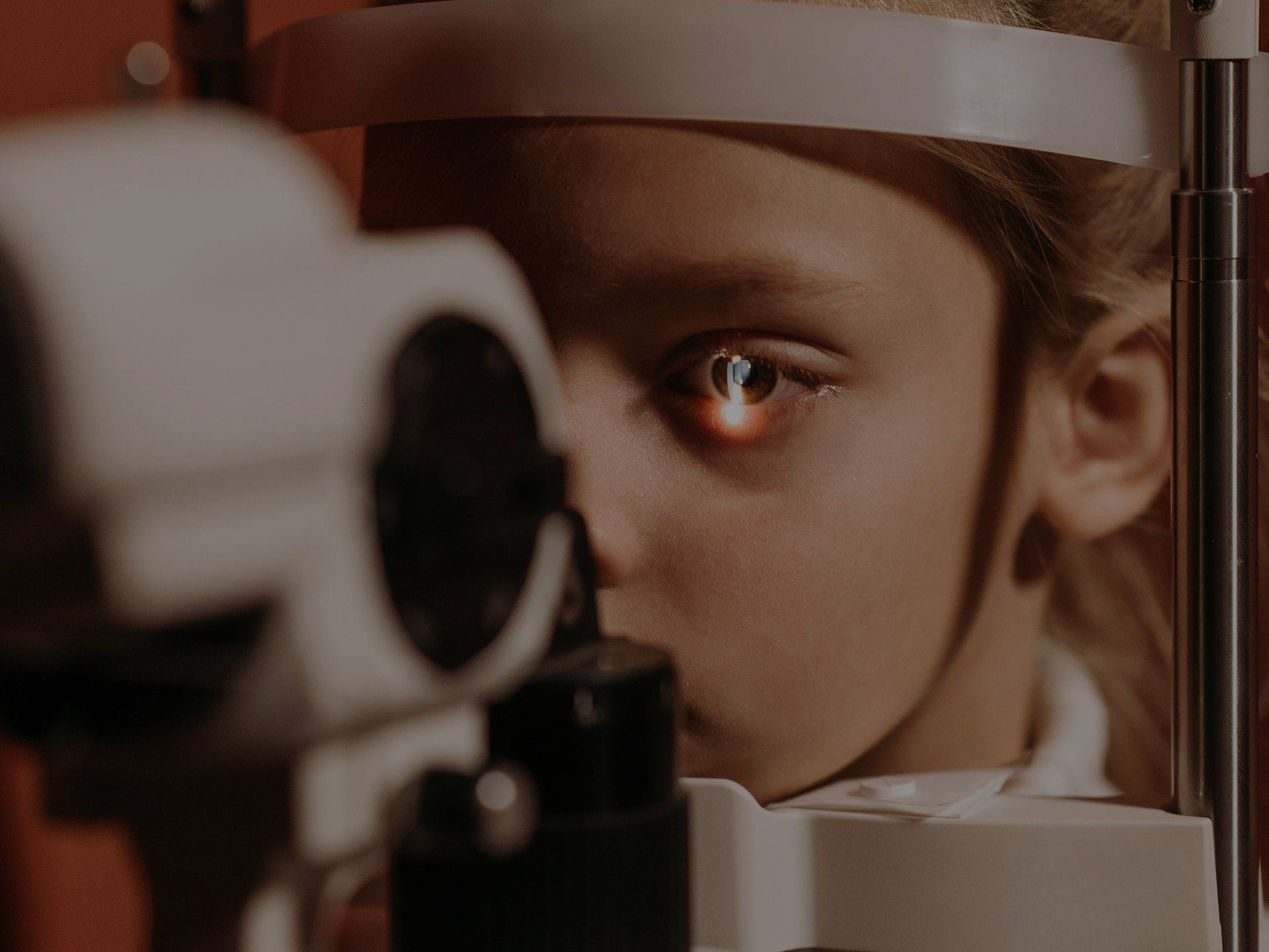 A young girl is getting her eyes examined by an ophthalmologist.