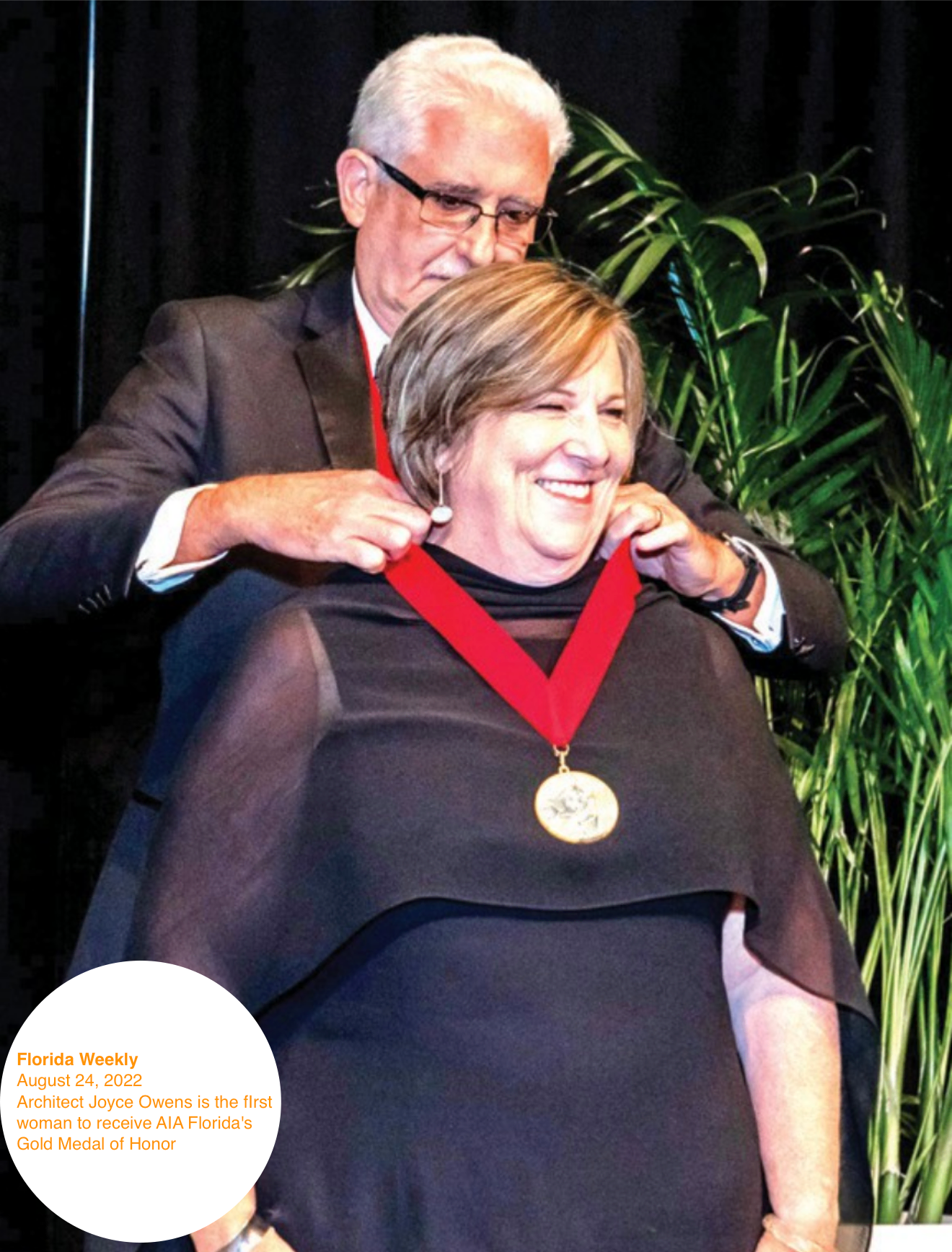 A man is putting a medal around a woman 's neck - Architecture Joyce Owens