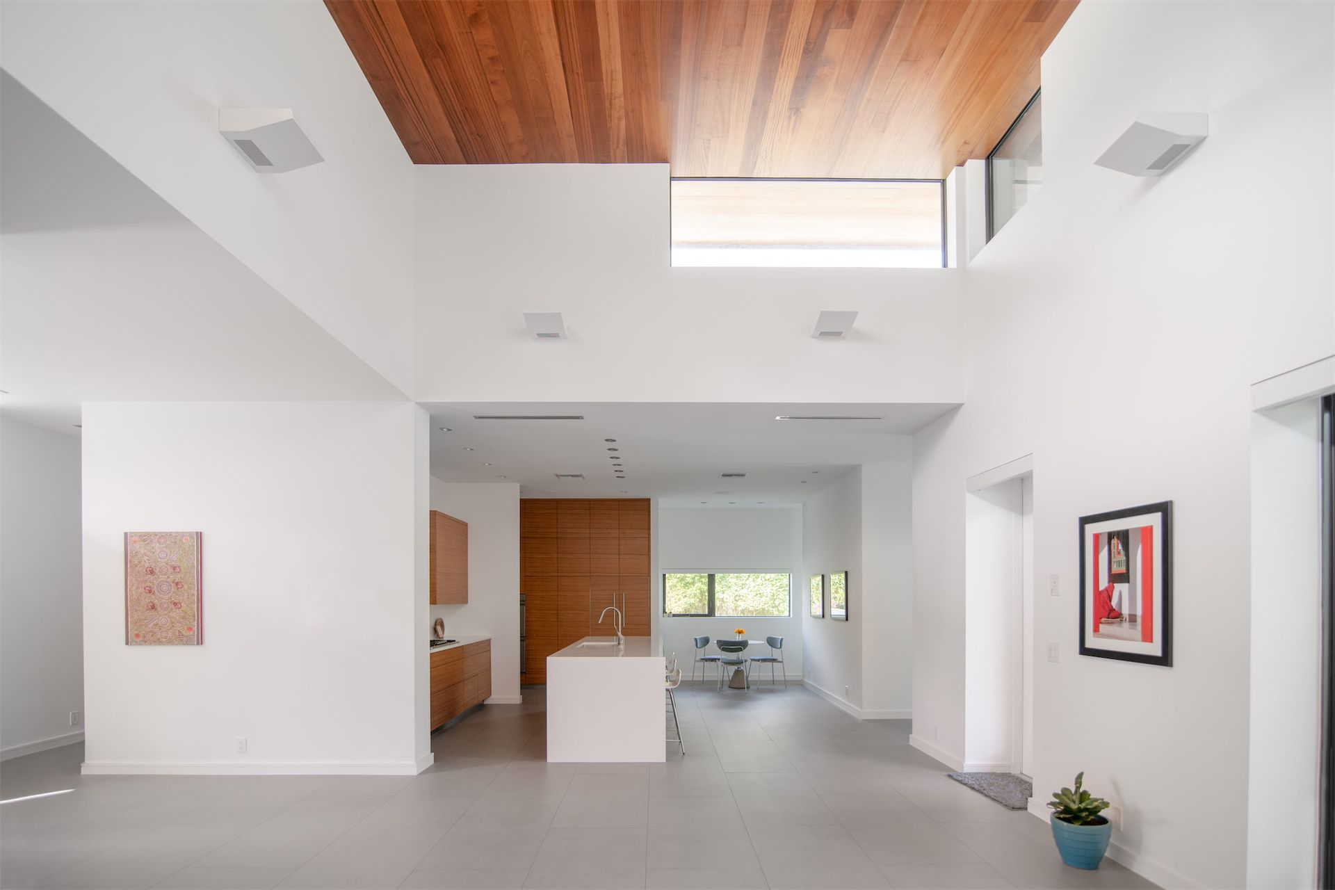 a modern kitchen with a wooden ceiling and white cabinets