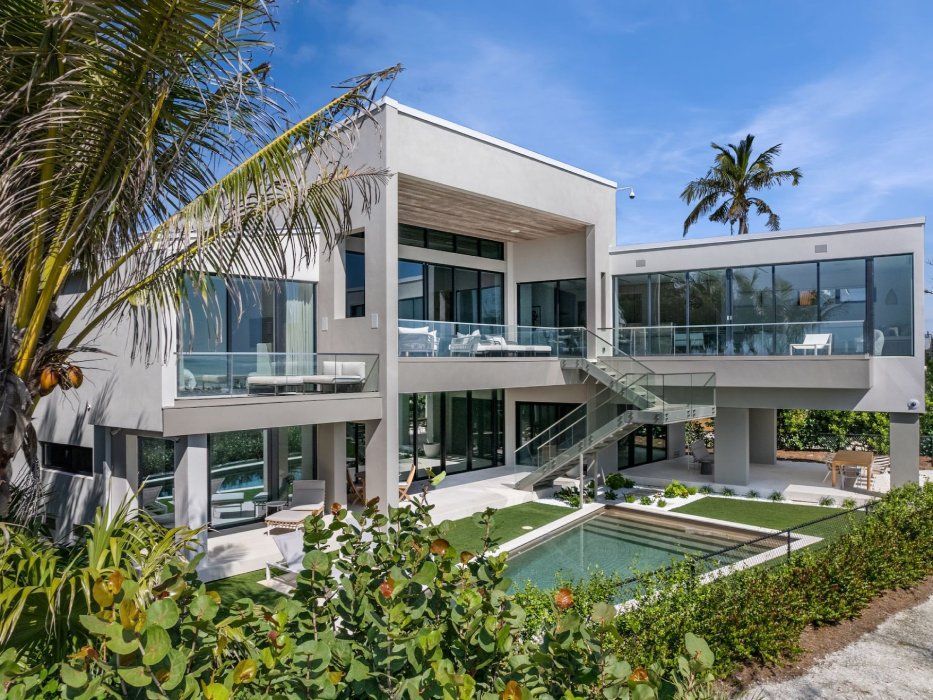 a large white house sits in the middle of a lush green  lawn