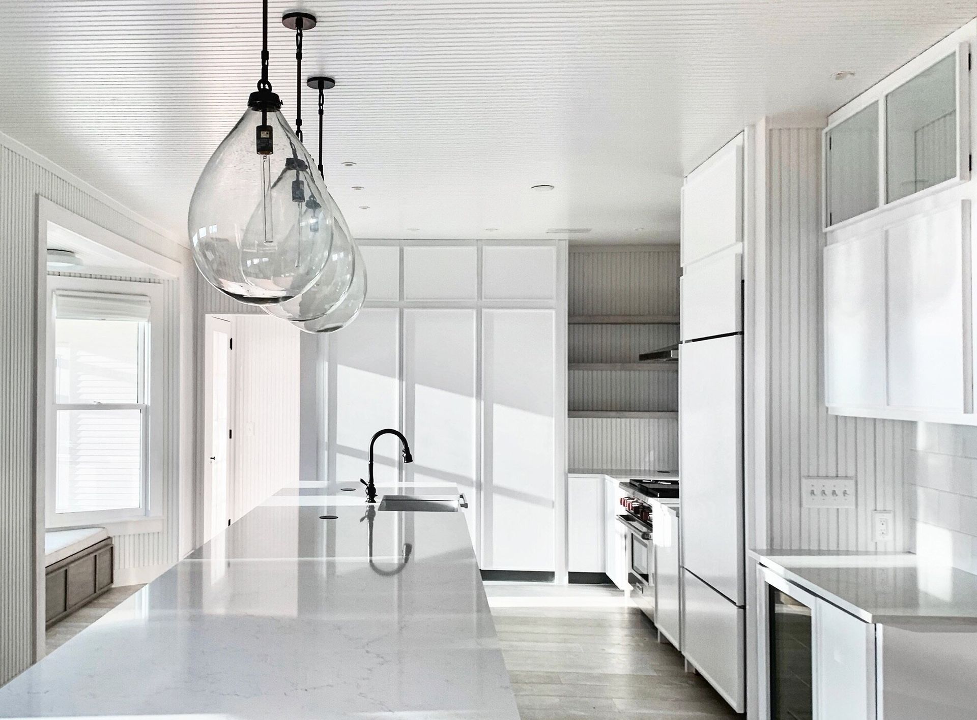 a renovated modern kitchen with white cabinets and stainless steel appliances
