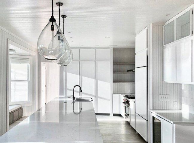 a modern kitchen with white cabinets and stainless steel appliances