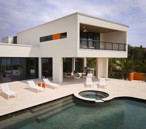 A large white house with a swimming pool in front of it