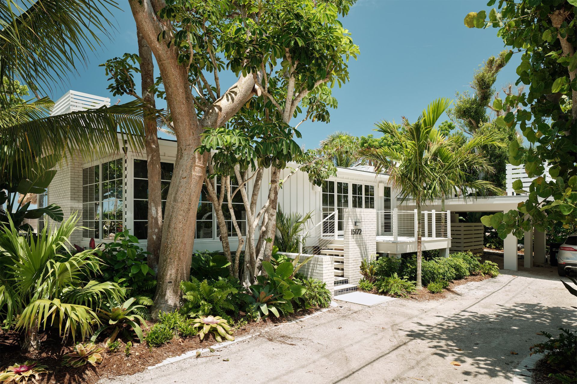 a white beach house with palm trees