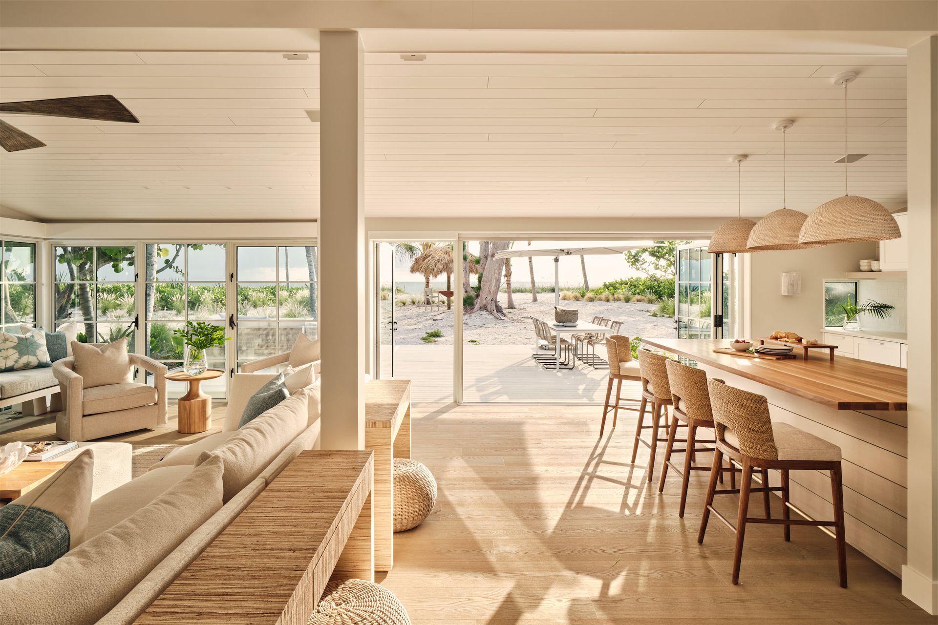 a living room and kitchen with a view of the beach