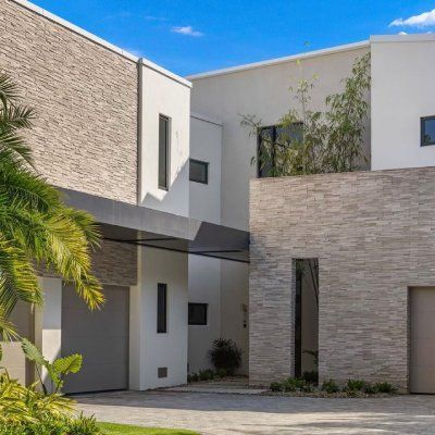 A modern house with a lot of windows and a garage.